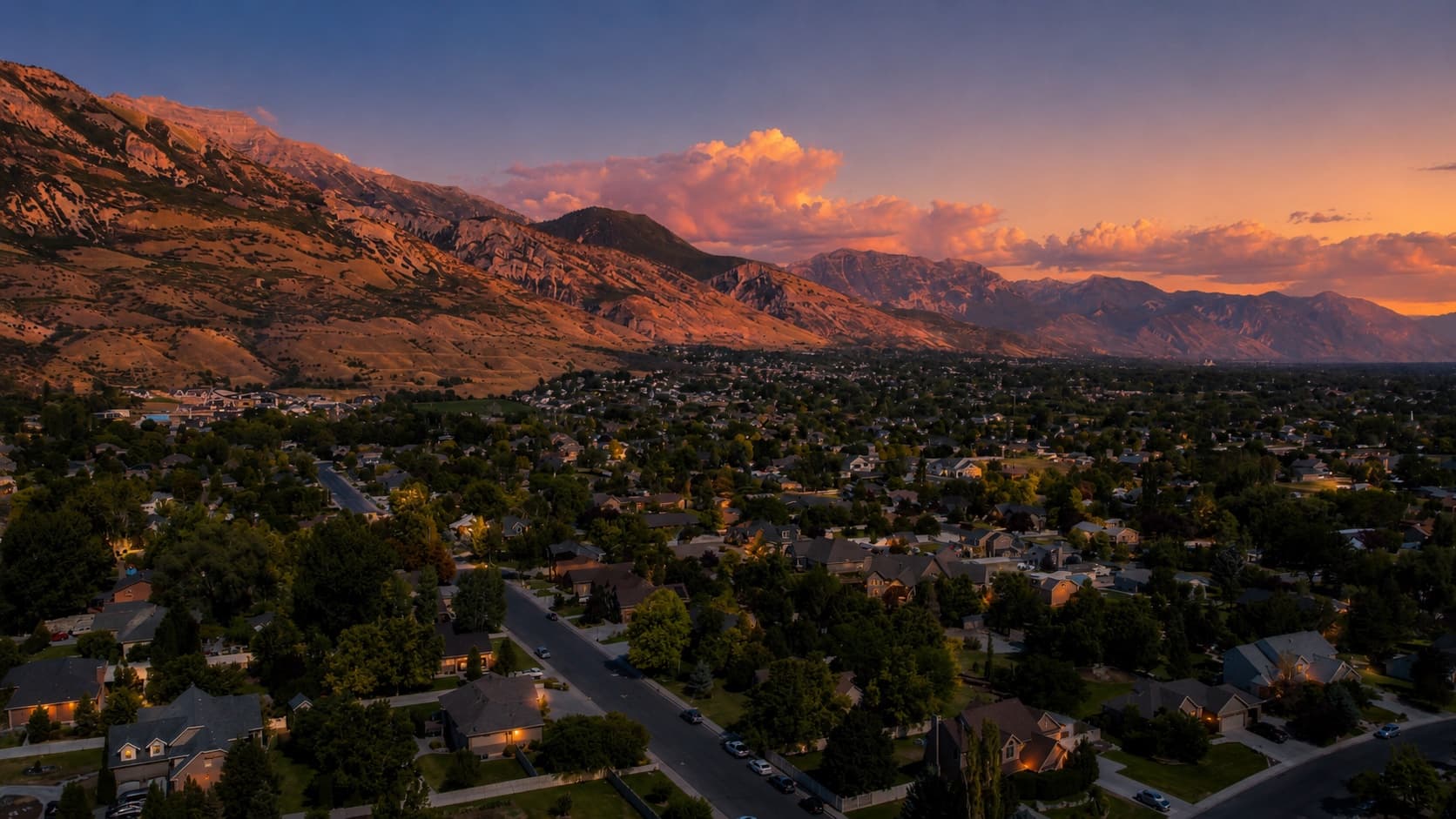 Utah Valley at dusk with the Wasatch mountains in alpenglow above a Utah County neighborhood