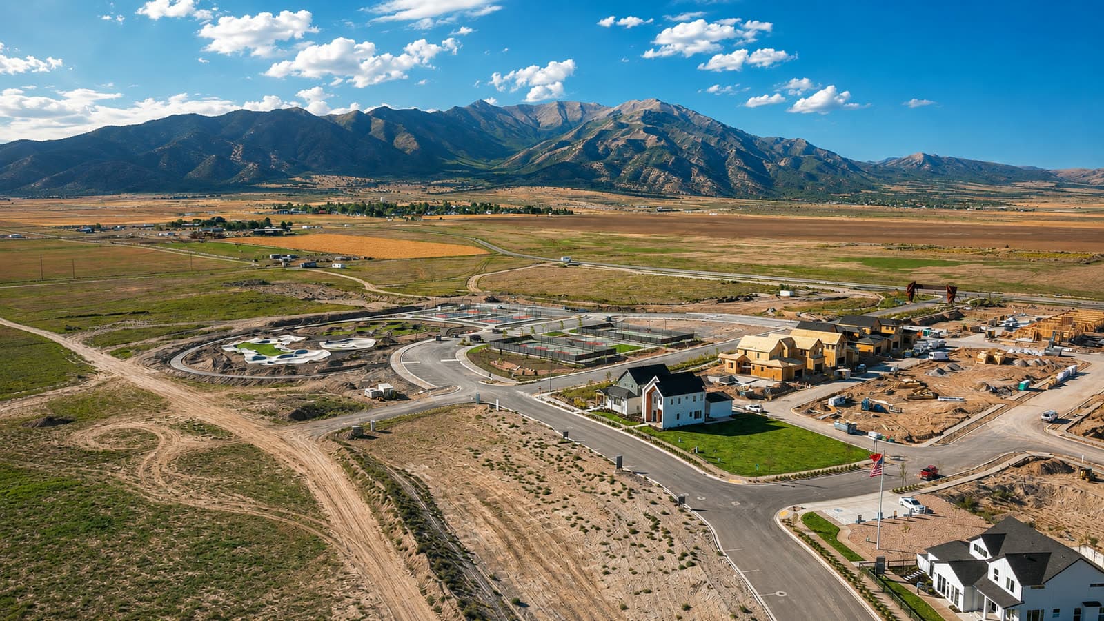 Wide aerial of Firefly in Cedar Valley, Eagle Mountain — finished homes and new construction with open valley and mountains beyond
