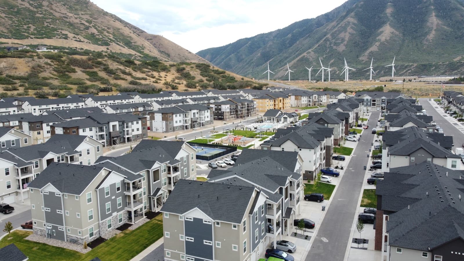 Harmony Ridge homes with pickleball courts and the Spanish Fork Canyon wind turbines beneath Maple Mountain