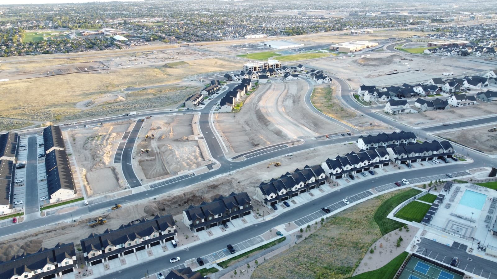 Aerial view of new Inverness phases under construction around the finished amenity core and pool