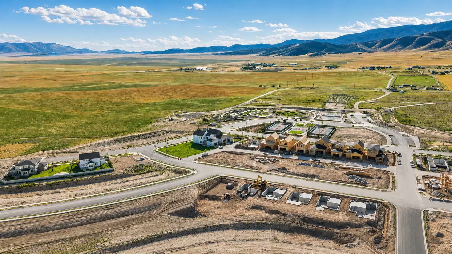 Aerial view of Firefly in Eagle Mountain, Utah — new homes and parkland in Cedar Valley with the mountains behind
