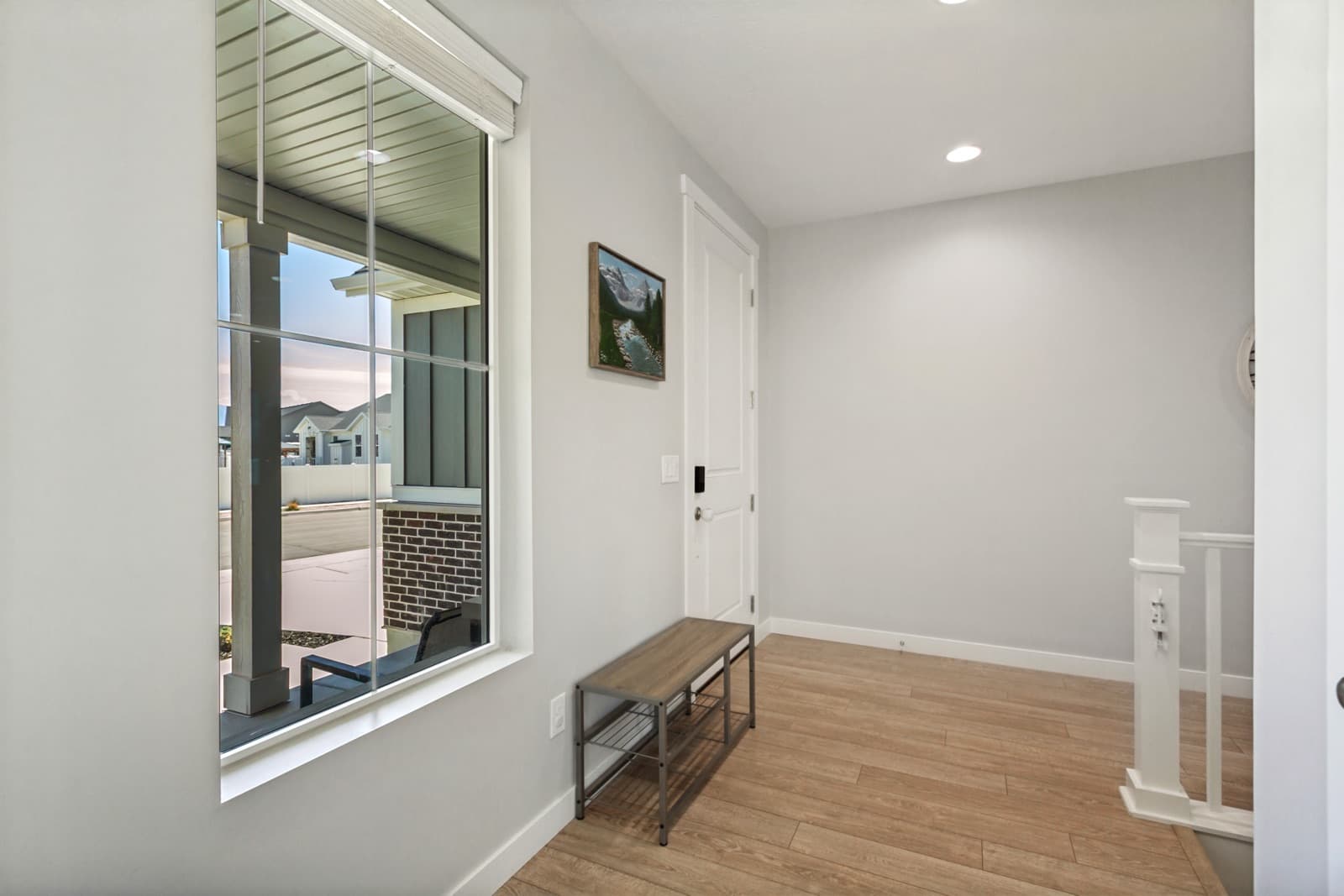 Entry with a bench under a window onto the front porch
