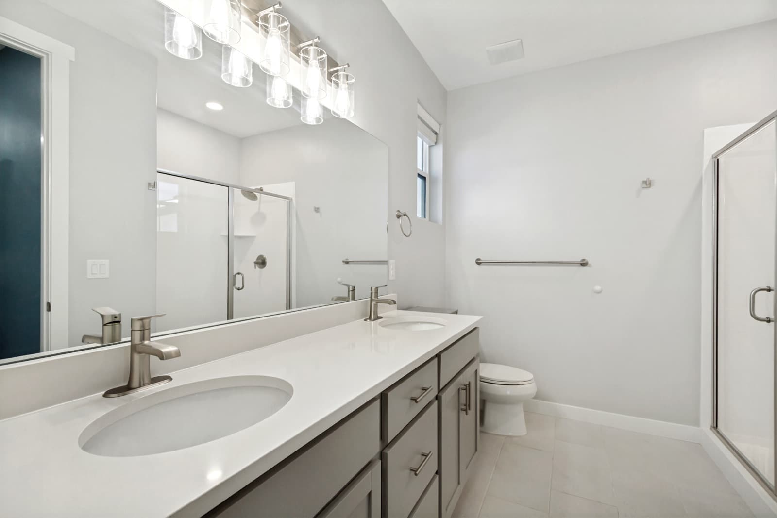 Primary bath with a double vanity and a glass shower