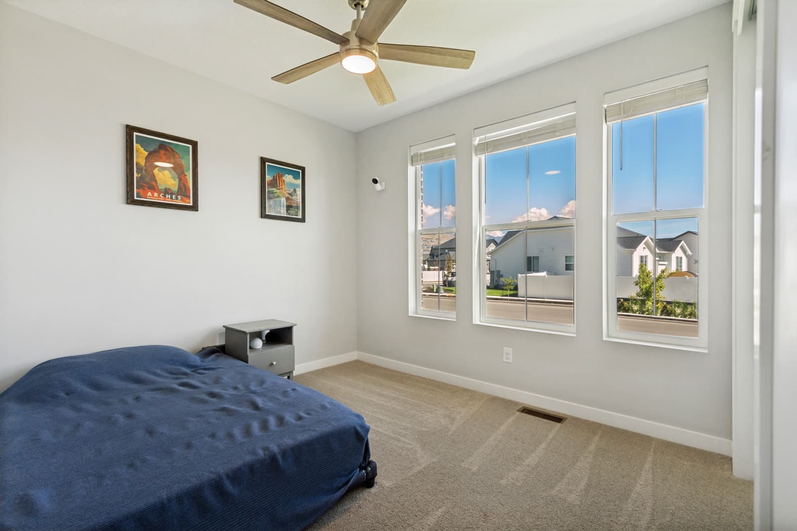 Front bedroom with three windows and a ceiling fan
