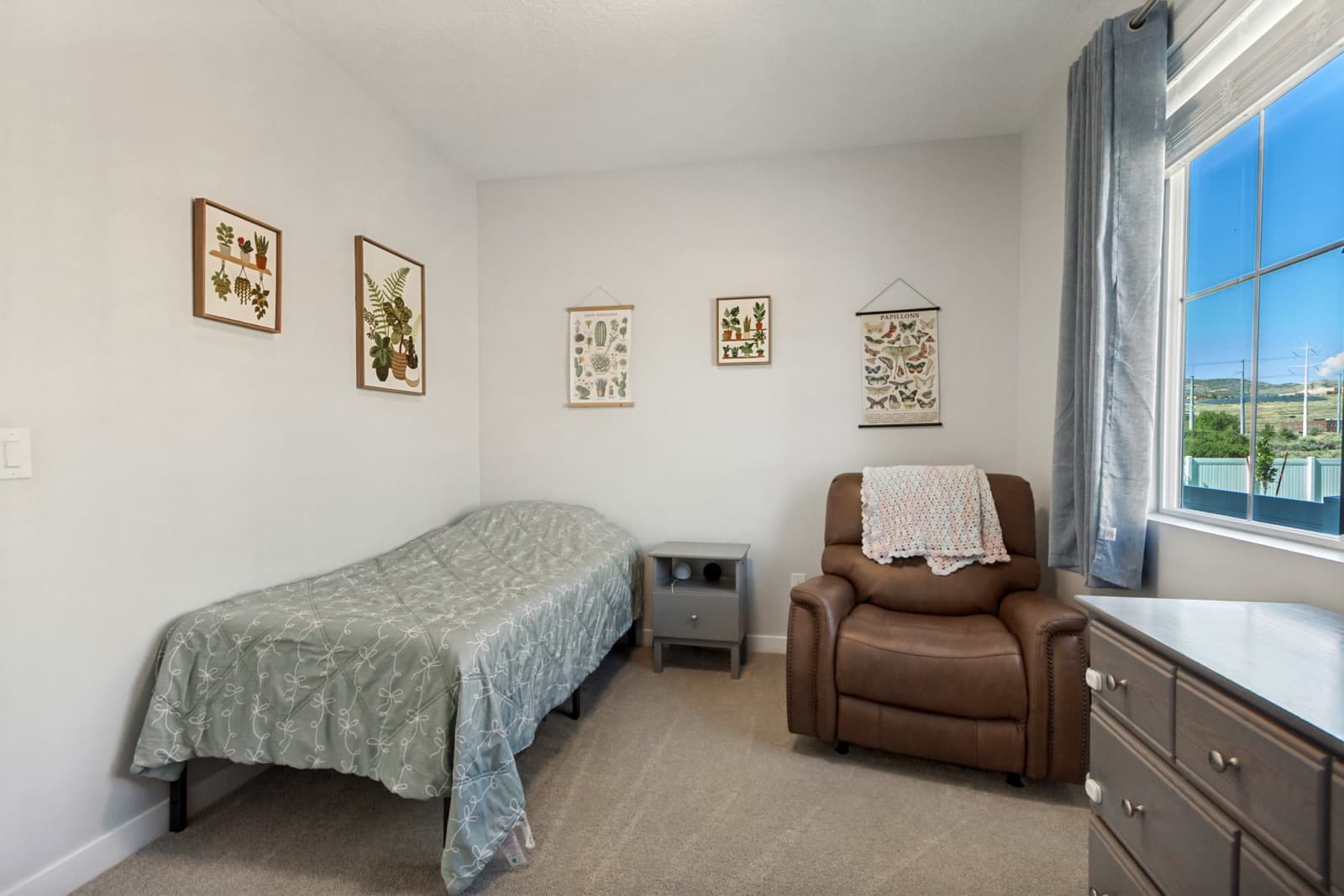 Third main-floor bedroom with a recliner corner and a window with a mountain view