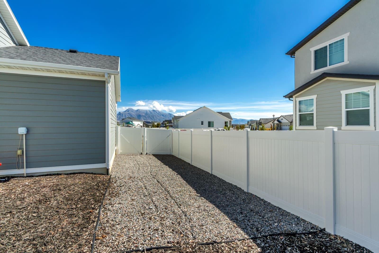 Gravel side yard with a double gate