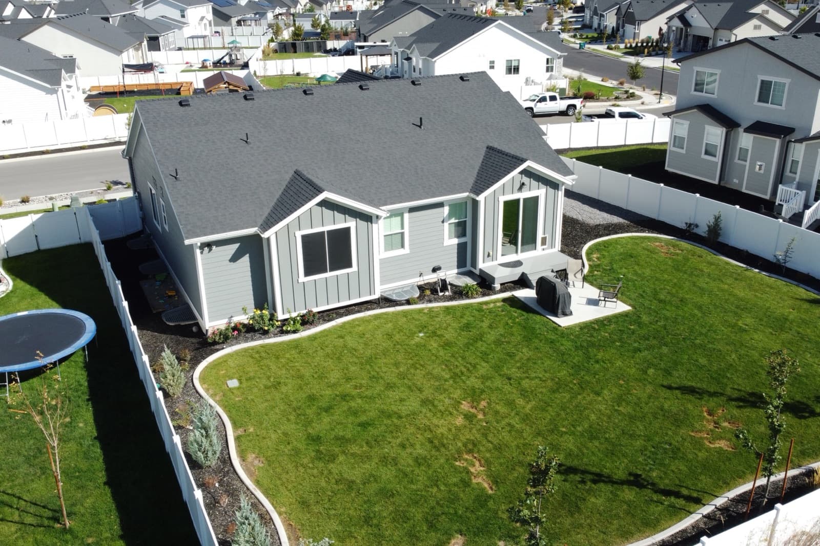 Aerial view of the curved, fenced backyard and patio