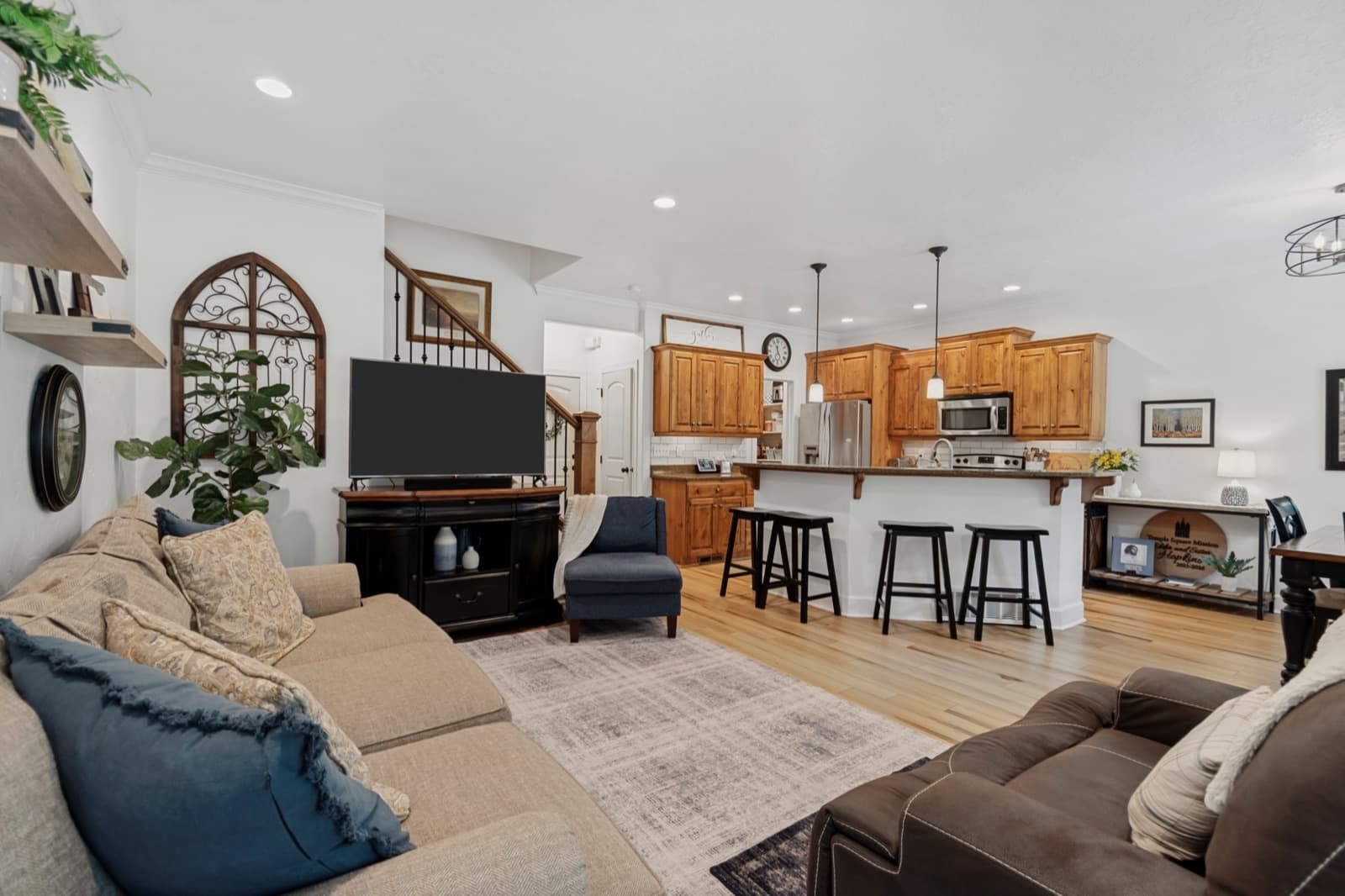 Great room open to the kitchen with luxury vinyl plank flooring and the staircase beyond