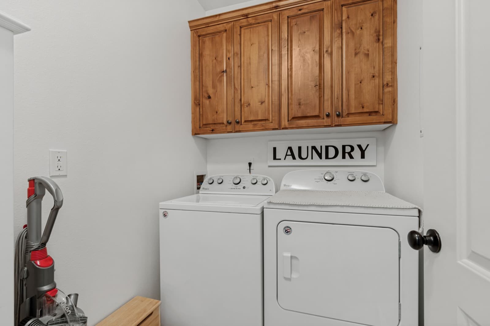Dedicated laundry room with upper cabinets, washer, and dryer
