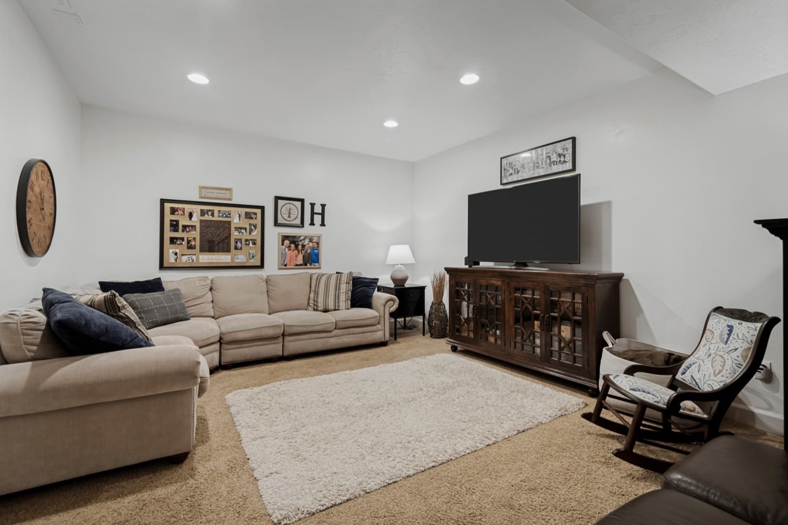 Large finished lower-level family room with recessed lighting and a media wall